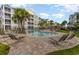 Community pool surrounded by lounge chairs, lush landscaping, and tropical palm trees at 189 Ella Kinley Circle # 203, Myrtle Beach, SC 29588