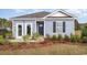 Charming single-story home featuring blue siding, manicured landscaping, and inviting entryway at 204 Jeff Waters Circle, Longs, SC 29568