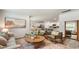Open-concept living room featuring a comfortable sofa, green armchairs, and an open kitchen at 207 Calm Dr., Little River, SC 29566