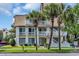 Inviting condo featuring white balconies and stairs accented by mature palm trees and well-maintained landscaping at 211 76Th Ave. N # A-2, Myrtle Beach, SC 29572
