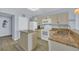 Kitchen with granite counters, stainless sink, island and white appliances at 2507 S Ocean Blvd. # 802, North Myrtle Beach, SC 29582