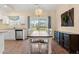 Bright dining area adjacent to the kitchen with white chairs, wood table, and elegant lighting fixture at 2827 Allen Dew Rd., Conway, SC 29527