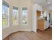 Bright kitchenette featuring wood-look flooring, three large windows and white cabinets at 2827 Allen Dew Rd., Conway, SC 29527
