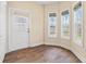 Bright sunroom featuring wood-look flooring, three large windows and a white entry door at 2827 Allen Dew Rd., Conway, SC 29527