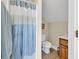 Cozy bathroom featuring a shower with blue patterned curtain, toilet, and vanity with wood cabinet at 3148 Bayhaven Dr., Myrtle Beach, SC 29579
