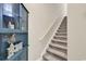 Carpeted staircase featuring a handrail and a stylish blue cabinet with glass doors at 3148 Bayhaven Dr., Myrtle Beach, SC 29579