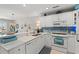 Bright, white kitchen featuring white appliances, cabinets, a breakfast bar, and blue backsplash at 323 14Th Ave. S # B, Surfside Beach, SC 29575