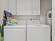 Functional laundry room with white washer, dryer, overhead cabinets and water heater at 323 14Th Ave. S # B, Surfside Beach, SC 29575