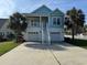 Charming two-story home featuring a spacious driveway, dual garages, and inviting staircase with palm trees at 3851 Journeys End Rd., Murrells Inlet, SC 29576