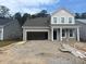 Exterior view of a two-story home with tan siding and an unfinished yard showcasing construction in progress at 393 Sun Colony Blvd., Longs, SC 29568