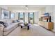 This living room features a ceiling fan, large windows, and stylish decor at 393 Sun Colony Blvd., Longs, SC 29568