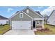 Charming one-story home features a garage and black front door with stone veneer accent at 4105 Da Vinci Dr., Myrtle Beach, SC 29579
