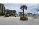 Community area with palm trees, seating, and a path leading to nearby buildings at 415 Ocean Creek Dr. # 2443, Myrtle Beach, SC 29572