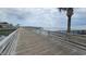 Scenic wooden boardwalk leading to the beach, offering a serene view of the water and surrounding area at 415 Ocean Creek Dr. # 2443, Myrtle Beach, SC 29572