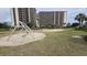 A fun playground with swings and a volleyball court, set against a backdrop of high-rise buildings at 415 Ocean Creek Dr. # 2443, Myrtle Beach, SC 29572