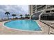 A beautiful blue pool with sun loungers, surrounded by palm trees and a modern building at 415 Ocean Creek Dr. # 2443, Myrtle Beach, SC 29572