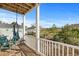 Enjoy views from this cozy balcony with wooden floors, white railings, comfortable chair and hanging hammock at 4387 Landing Rd., Little River, SC 29566