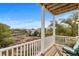 Relaxing covered balcony with wooden floors, white railing and outdoor seating overlooking marsh views at 4387 Landing Rd., Little River, SC 29566