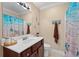 Well-lit bathroom with a single sink vanity, decorative mirror, and beach-themed shower curtain at 4387 Landing Rd., Little River, SC 29566