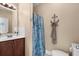 Cozy bathroom with anchor decoration, seashell shower curtain, wood vanity, and tiled backsplash at 4387 Landing Rd., Little River, SC 29566