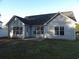 A home's back exterior with vinyl siding, a dark roof, and a door leading to an outdoor patio at 4664 Southgate Pkwy., Myrtle Beach, SC 29579