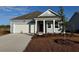 Charming single-story home with a red front door, attached garage, and manicured landscaping at 474 Blissful Ln., Little River, SC 29566