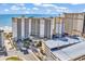 Beautiful aerial view of a light beige beachfront condominium with a parking deck, the beach, and the blue ocean at 4800 S Ocean Blvd. # 1103, North Myrtle Beach, SC 29582