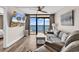 Bright living room with modern furniture, hardwood floors, a ceiling fan and sliding glass doors to an ocean view balcony at 4800 S Ocean Blvd. # 1103, North Myrtle Beach, SC 29582