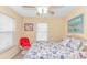 Inviting bedroom with a bright red chair, ceiling fan and beach-themed decor at 6001- 310 S Kings Hwy., Myrtle Beach, SC 29575