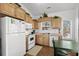 Well-lit kitchen featuring light wood cabinets, white appliances, and a dining area at 6001- L08 S Kings Hwy., Myrtle Beach, SC 29575