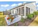 Backyard patio and exterior of a home with screened in porch, dining table, grill, and flower planters at 6096 Campanella St., Myrtle Beach, SC 29577