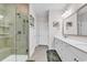 Well-lit bathroom showcases a tiled shower with a glass door and double sinks at 6096 Campanella St., Myrtle Beach, SC 29577
