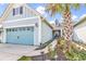 Charming two-story home featuring a blue garage door, complemented by a pathway and tropical foliage at 6096 Campanella St., Myrtle Beach, SC 29577
