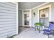 Welcoming porch with a seating area, complemented by charming decor and a view of the home's entrance at 6096 Campanella St., Myrtle Beach, SC 29577