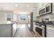 Bright kitchen with stainless steel appliances, white cabinets, and granite countertops, open to dining area at 633 Woodside Dr., Conway, SC 29526