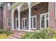 Charming brick home with a covered back porch, supported by white columns, perfect for outdoor relaxation at 653 Whispering Pines Ct., Murrells Inlet, SC 29576