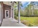 Covered back porch, with white pillars, overlooking the serene backyard and providing an idyllic outdoor living space at 653 Whispering Pines Ct., Murrells Inlet, SC 29576