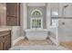 Soaking tub and tiled shower in a luxurious bathroom with large window and natural light at 653 Whispering Pines Ct., Murrells Inlet, SC 29576