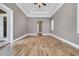 A large bedroom with a tray ceiling, and wood-look floors at 653 Whispering Pines Ct., Murrells Inlet, SC 29576