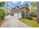 Back exterior view of home showcasing a driveway leading to a three-car garage and a fenced yard at 653 Whispering Pines Ct., Murrells Inlet, SC 29576