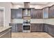 Close up view of modern kitchen featuring gas range, subway tile backsplash, and rich wood cabinetry at 653 Whispering Pines Ct., Murrells Inlet, SC 29576