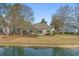 Back of house and backyard featuring well-maintained landscaping and serene waterfront views at 742 Camden Circle, Pawleys Island, SC 29585