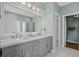 Bathroom with a dual sink vanity, a glass-enclosed shower, and a walk-in closet at 742 Camden Circle, Pawleys Island, SC 29585