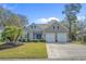 Charming single-Gathering home featuring a well-maintained lawn, palm tree, and two-car garage at 742 Camden Circle, Pawleys Island, SC 29585