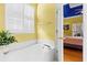 Bright bathroom features a bath tub with windows and access to the bedroom at 808 Arbor Ln., North Myrtle Beach, SC 29582