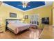 Relaxing bedroom features hardwood floors, yellow walls, blue ceiling, and a ceiling fan at 808 Arbor Ln., North Myrtle Beach, SC 29582