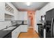 Well-lit kitchen features white cabinetry, black appliances, and functional layout with ample counter space at 808 Arbor Ln., North Myrtle Beach, SC 29582