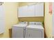 Bright laundry room with side-by-side washer and dryer and white cabinets at 808 Arbor Ln., North Myrtle Beach, SC 29582