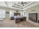 Luxurious primary bedroom with a tray ceiling, ample natural light, and stylish furnishings at 124 Mesa Raven Dr., Longs, SC 29568