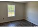This cozy bedroom features a window overlooking a verdant scene and sleek wood-look flooring at 1395 Knotty Branch Rd., Conway, SC 29527